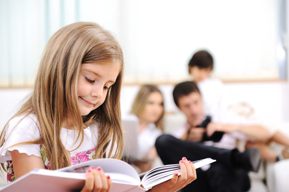 Little girl reading in home, indoor with happy family