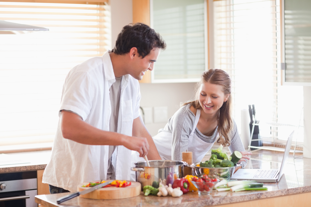 Young couple using the internet to look up recipe